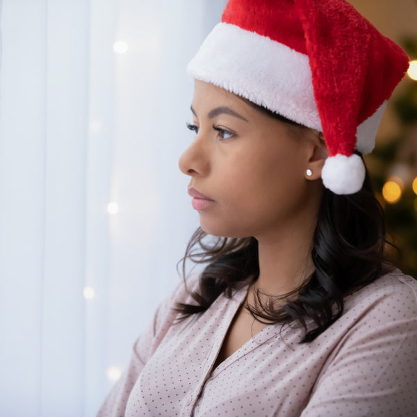 woman stressed on couch by christmas tree