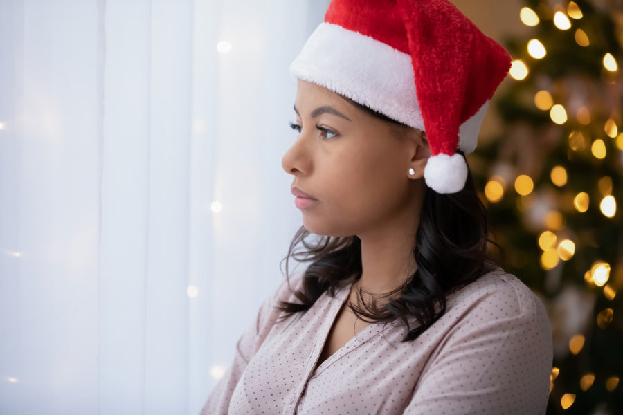 woman stressed on couch by christmas tree