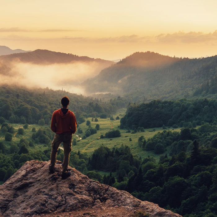 Man watching sunset on cliff