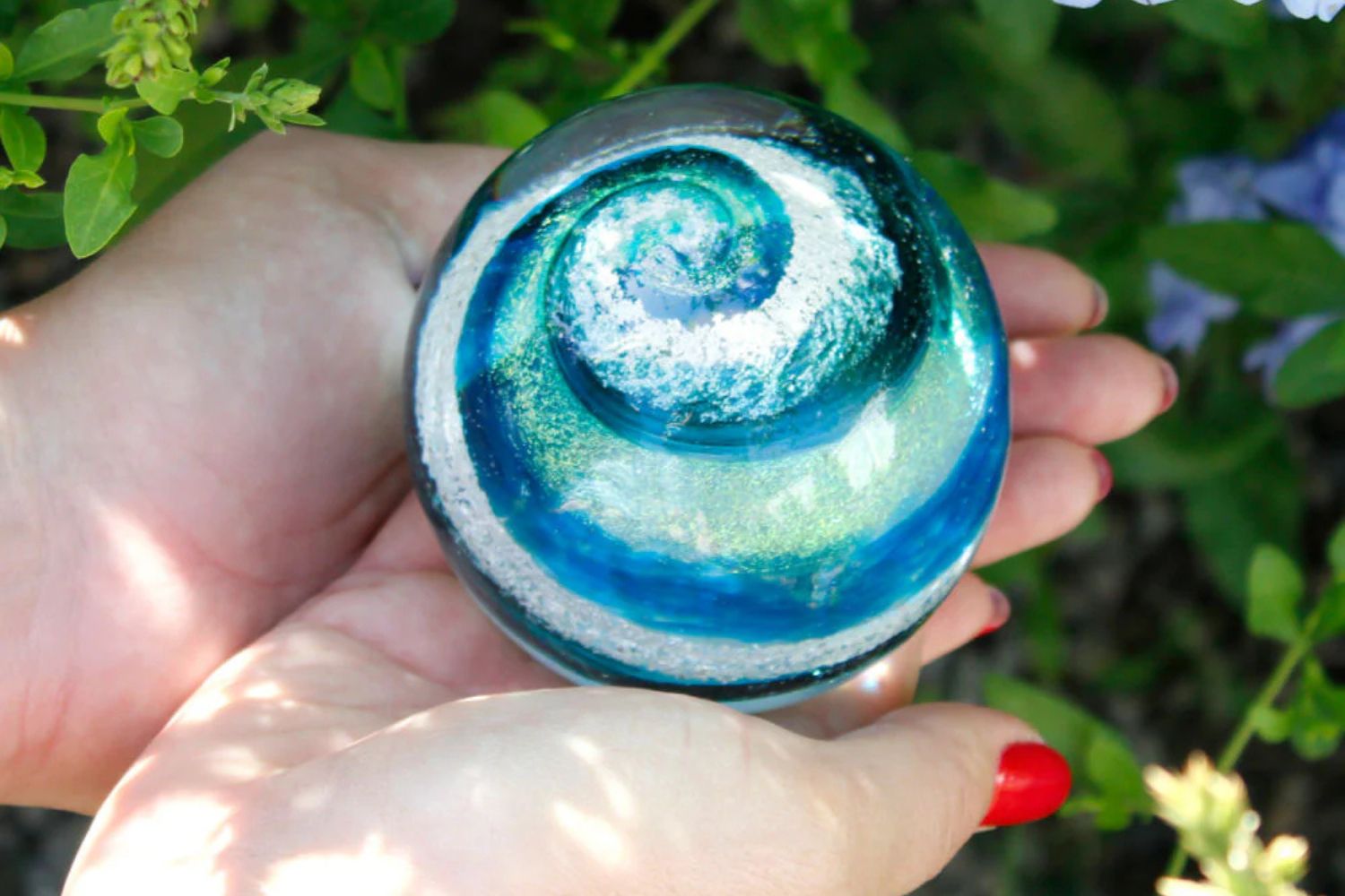 woman holding blue glass memorial stone