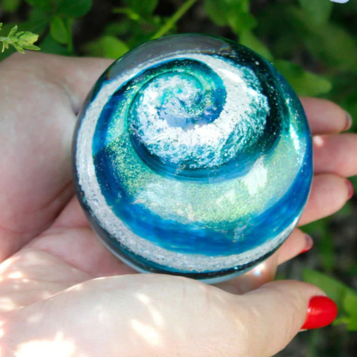 woman holding blue glass memorial stone