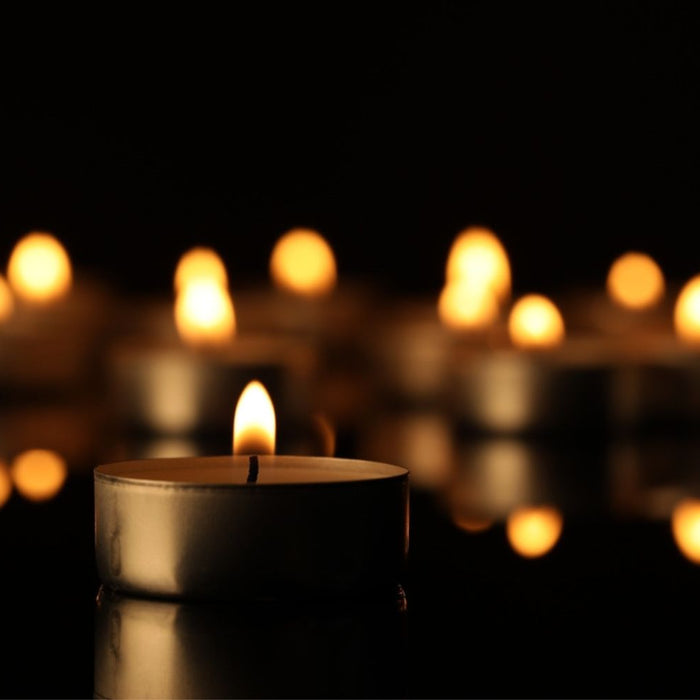 Burning candle on surface in darkness