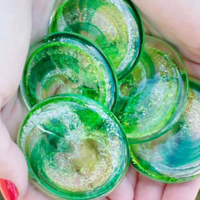 green glass cremation orbs in hands
