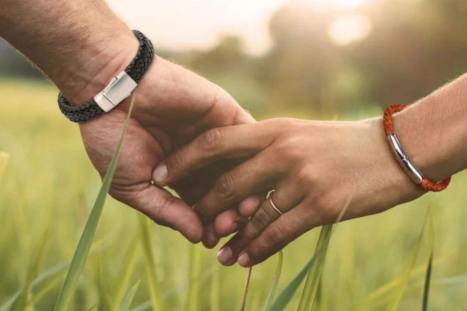 people holding hands in grass