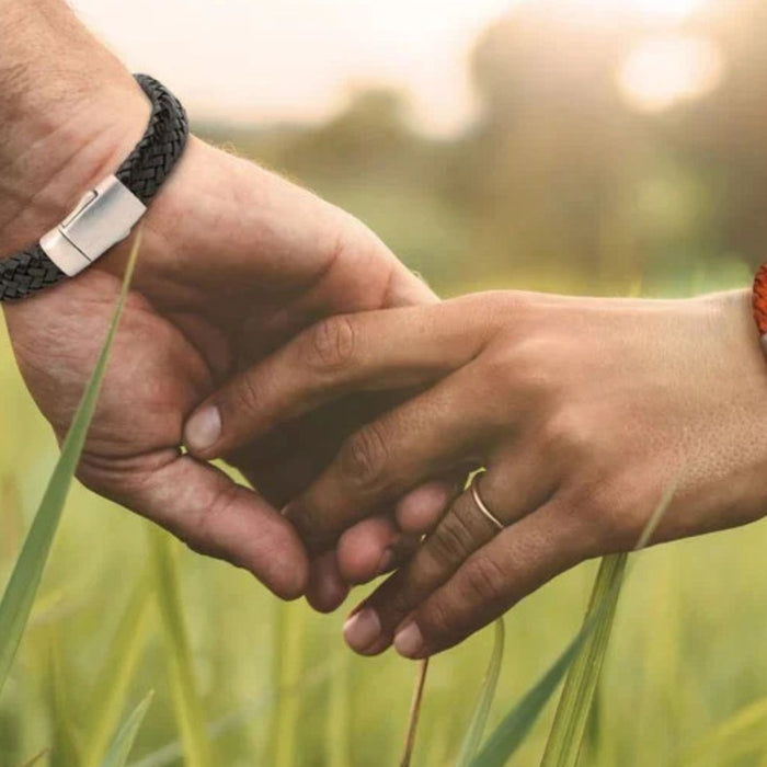 people holding hands in grass