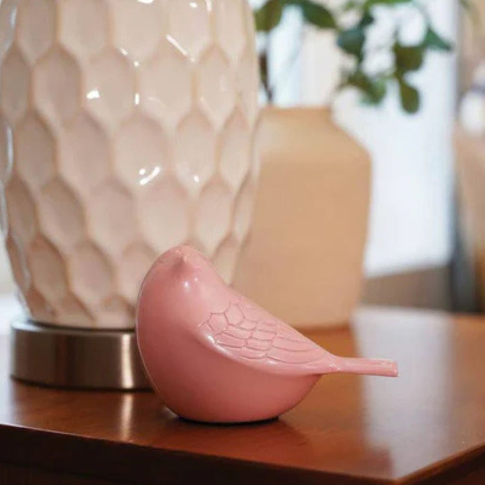 Pink songbird on a side table