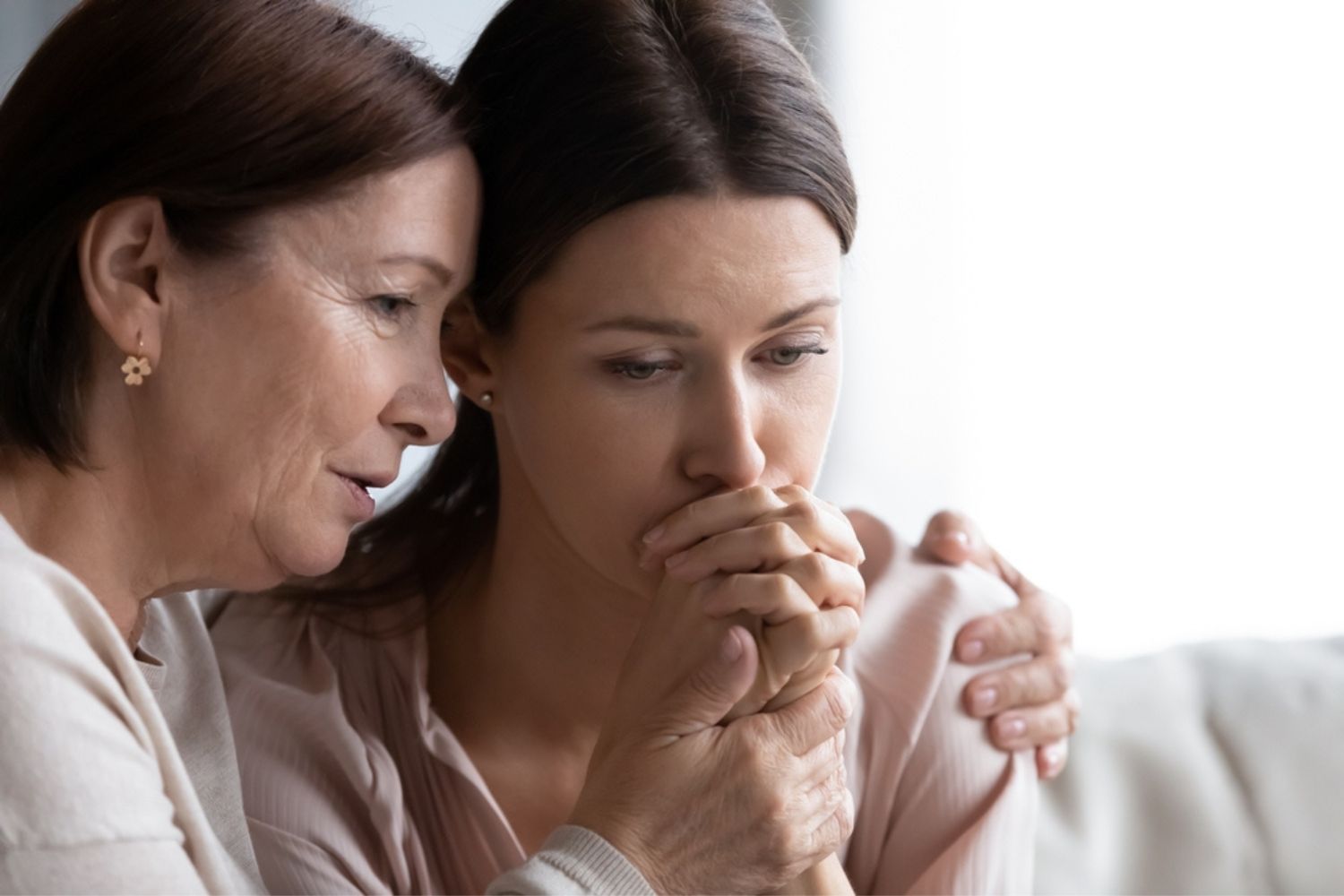 worried mature mom comforting sad adult daughter