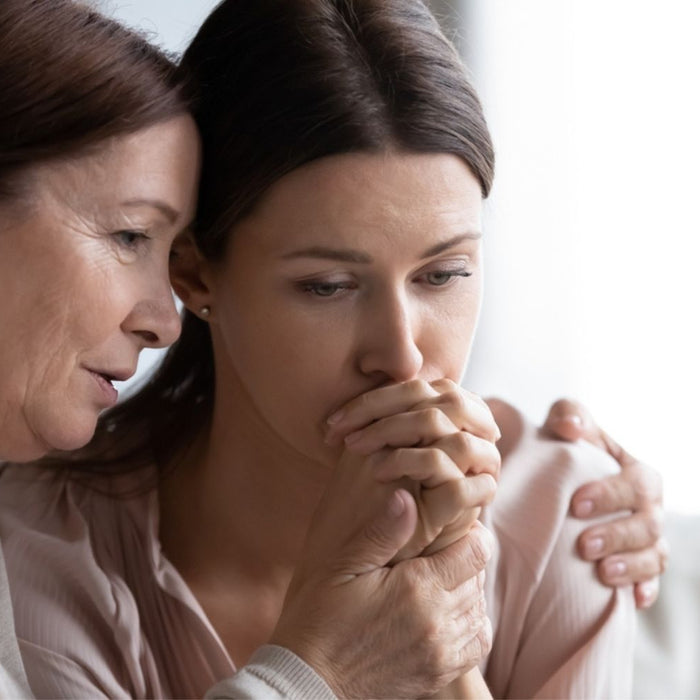 worried mature mom comforting sad adult daughter